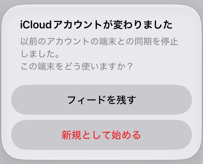 「iCloudアカウントが変わりました」の画面。以前のアカウントの端末との同期を停止したと説明され、「フィードを残す」と赤い「新規として始める」が並んでいる